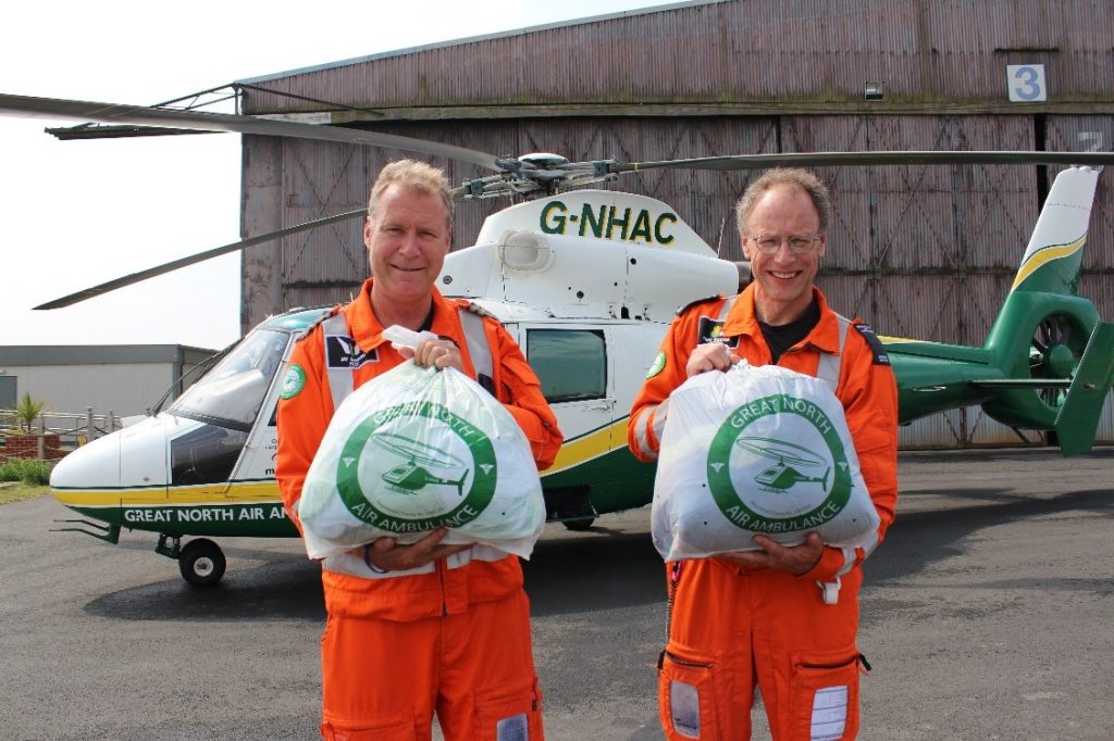 gnaas pilot jay steward and doctor theo weston with clothing collection bags