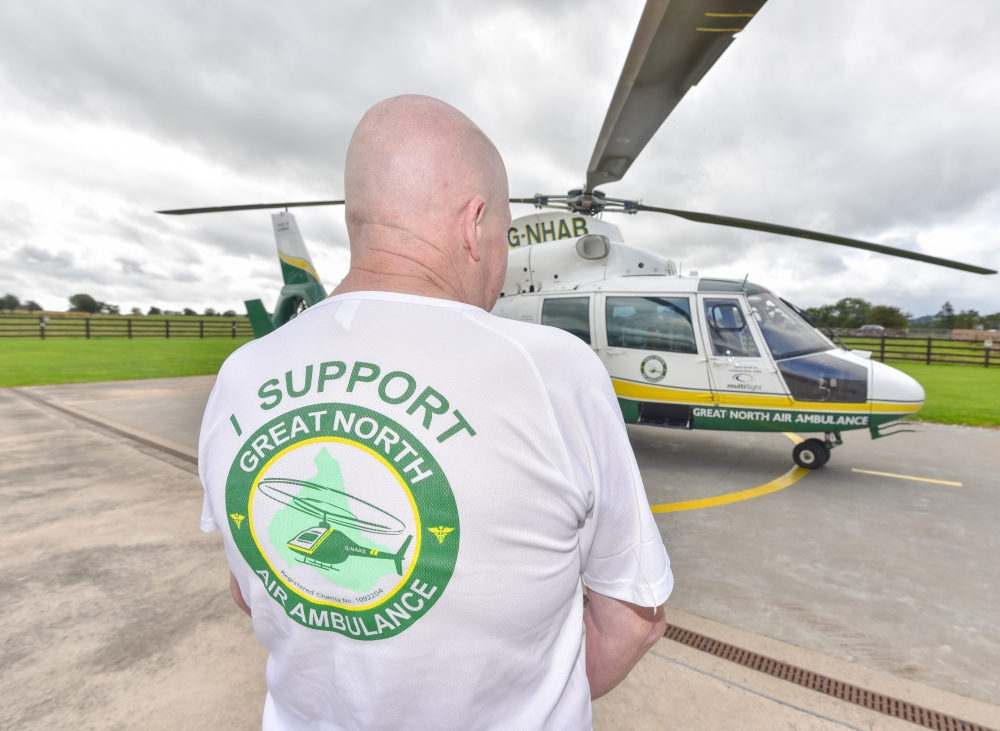 man wearing white gnaas logo shirt at langwathby base