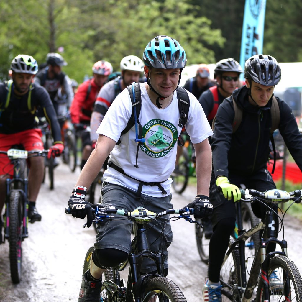 gnaas fundraisers cycling wearing t-shirt for great north air ambulance service